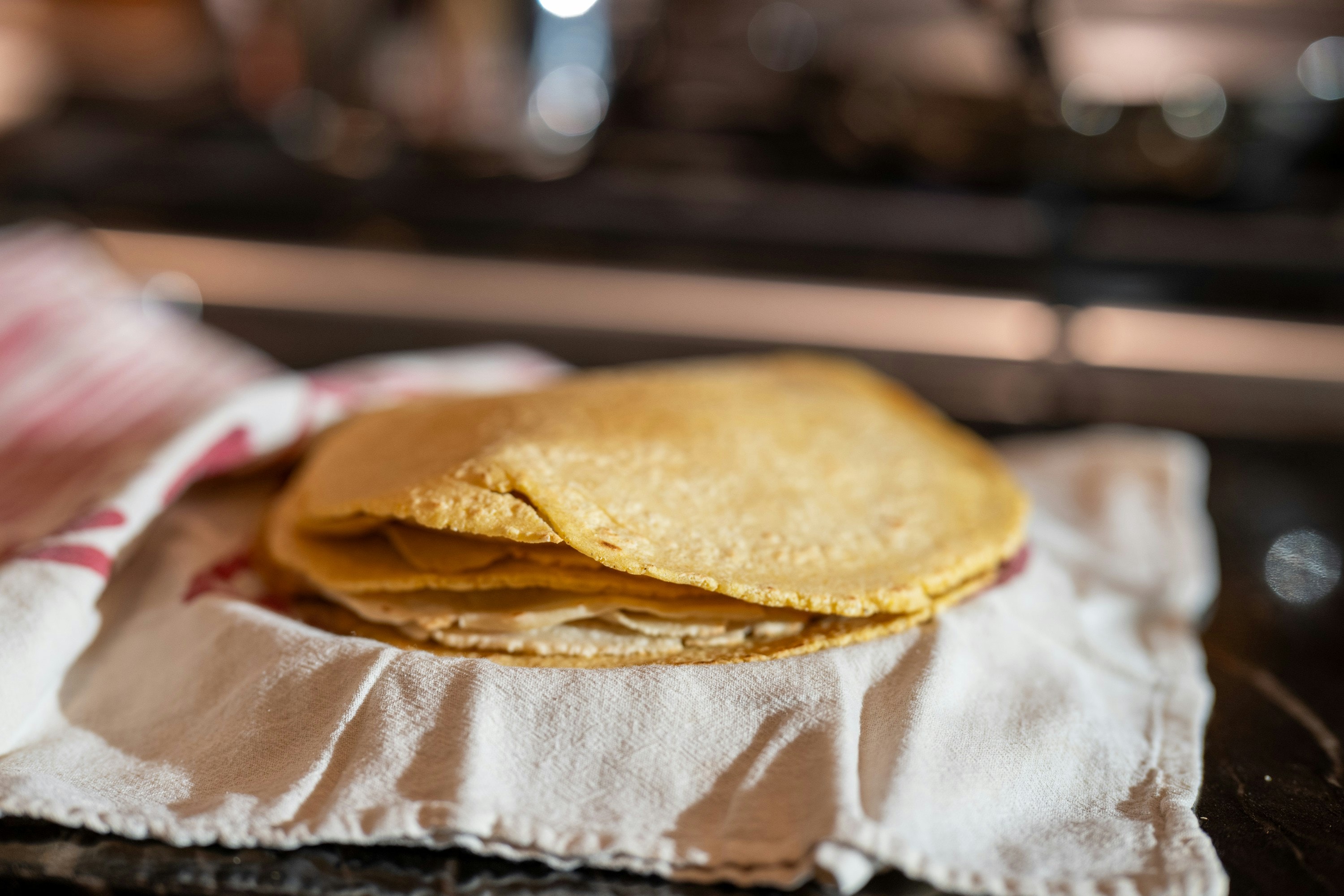 Fresh masa tortilla being pressed by hand